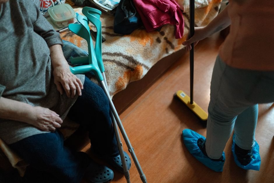 Aide assisting a veteran receiving VA home health aide benefits at home